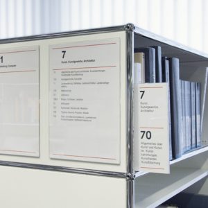 Schild Slim Magnetic, angebracht an einem USM-Bücherregal